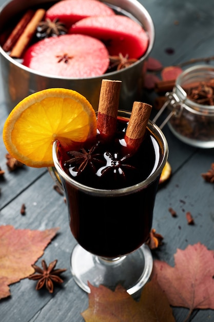 Mulled wine. Glass of winter hot drink with citrus, apple and spices.
