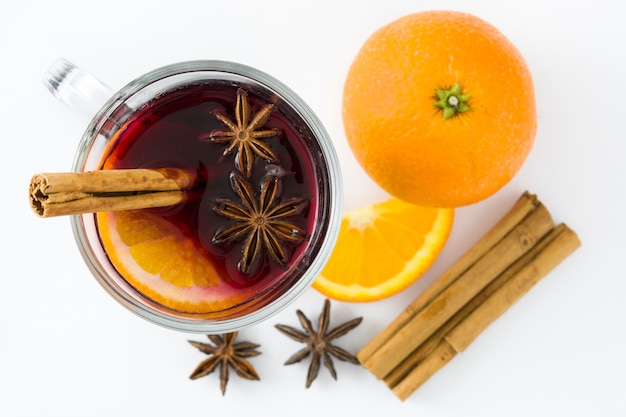Mulled wine in glass with spice and fruit isolated on white