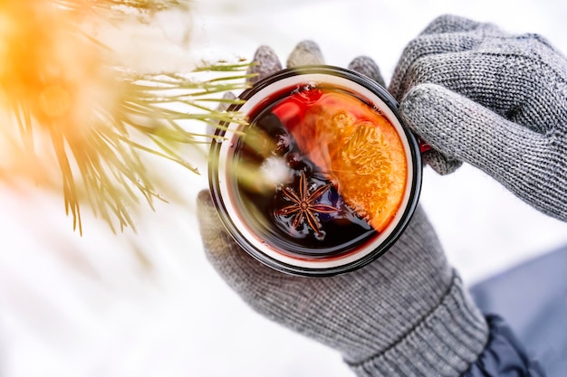 照片加香料的热葡萄酒的一个女孩在森林冬季降雪热饮和芳香的年代……