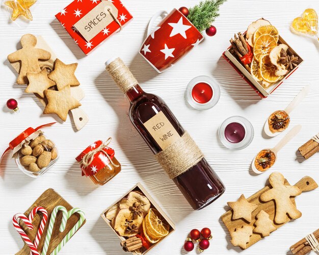 mulled wine ingredients christmas holiday hot winter drink bottle red wine dried fruits candy honey spices red mug on white wood