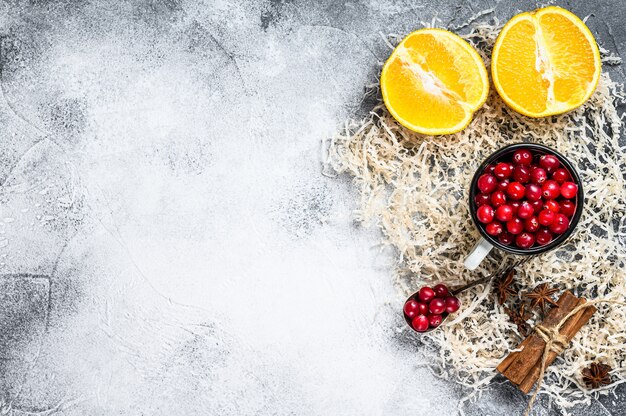 Mulled Wine recipe  Ingredients with cranberries, oranges, cinnamon, anise and cardamom  Gray surface    surface