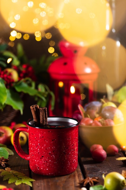 Mulled wine in a red mug on the autumn table