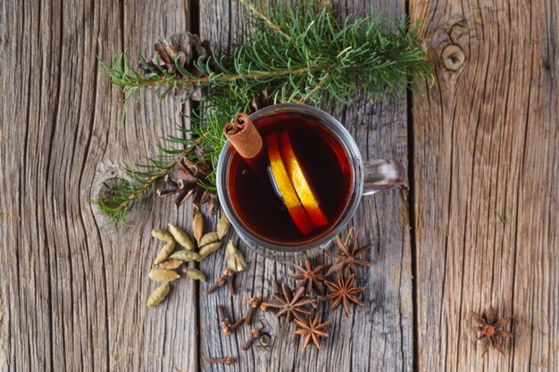 Mulled wine and spices on weathered wooden table