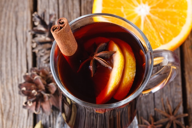 Mulled wine and spices on weathered wooden table