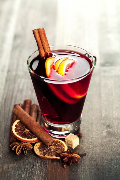 Mulled wine and spices on wooden background. Selective focus.