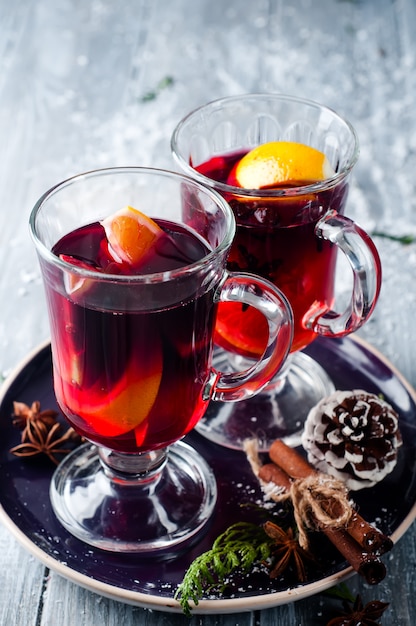 Mulled wine and spices on wooden background.