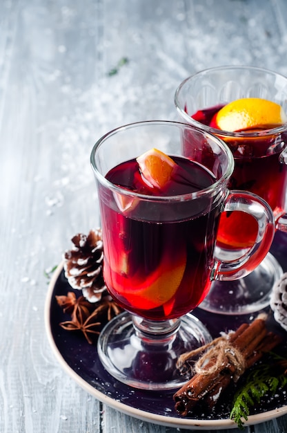 Mulled wine and spices on wooden background.