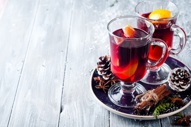 Mulled wine and spices on wooden background.