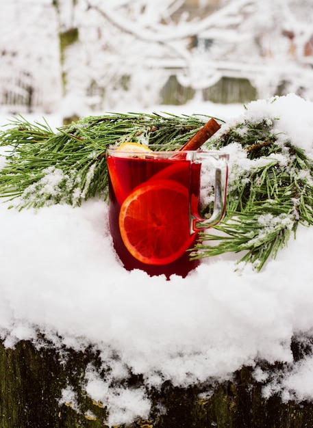 Mulled wine on the street in the snow with a branch of pine