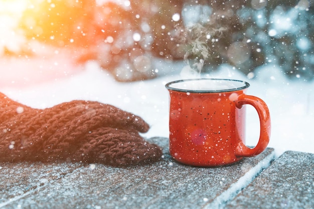 Photo mulled wine or tea on a wooden background during a snowfall in the forest winter hot drinks with aro...