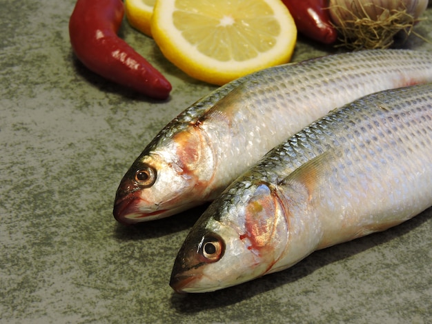 ボラとスパイス。 2つの生の魚とレモン。