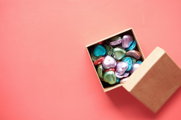 Multi color heart shape candy in a box on red
