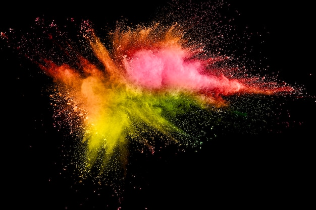 Photo multi color powder explosion on black background. launched colorful dust  particles splash