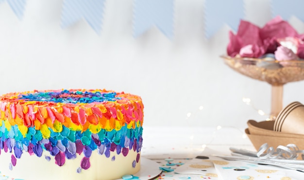Разноцветный праздничный торт украшен кремом. Концепция вечеринки по случаю дня рождения.