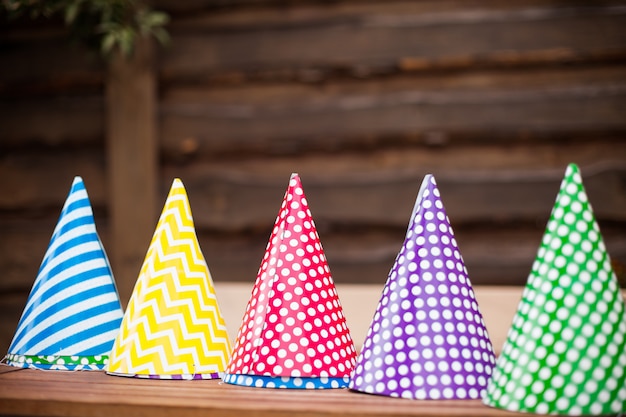 Multi-colored birthday hats in the shape of a cone.