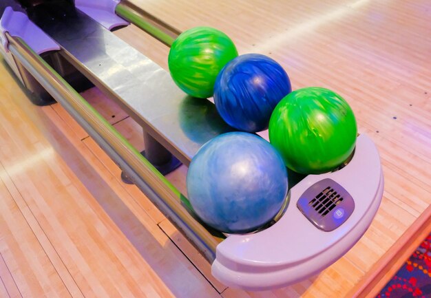 Multi colored bowling balls on rack at bowling alley