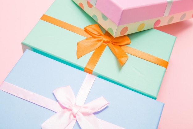 Multi-colored boxes with bows on a pink background