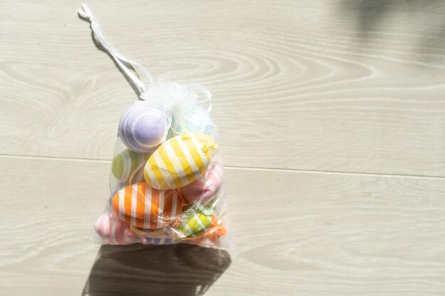 multi-colored chicken eggs in bag mesh on white background. easter.