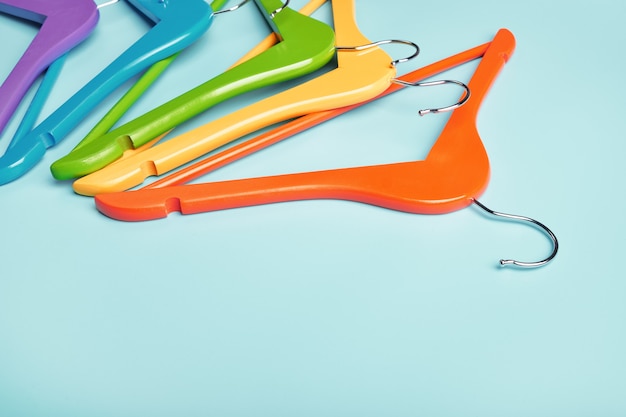 Multi-colored clothes hangers on a blue background. Concept of shopping and sale.