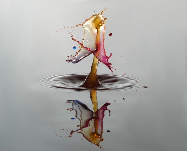 Photo multi colored drop splashing on water