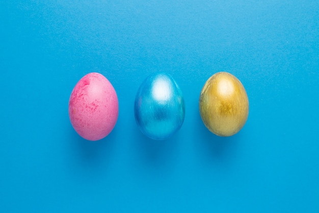 Multi-colored Easter eggs on a blue isolated background. Easter is a bright holiday.