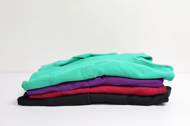 Multi colored female shirts with striped on hangers against a white background