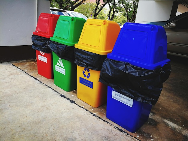 Photo multi colored garbage bins on footpath