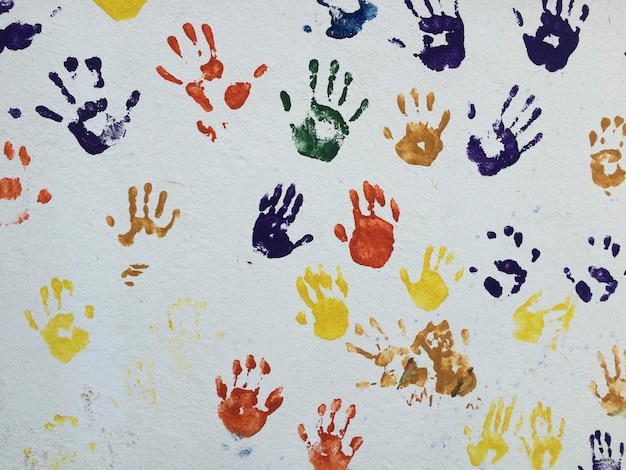 Photo multi colored handprints on wall