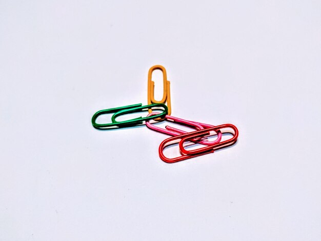 Photo multi colored paper clips on white background