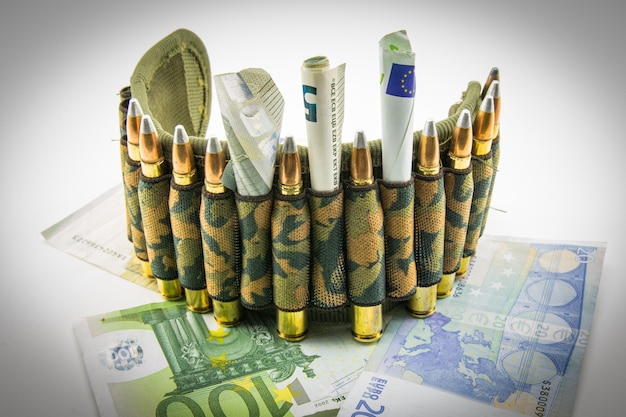 사진 다채로운 종이 화폐와  바탕에 벨트에 있는 총알