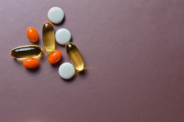 Разноцветные таблетки и витамины в капсулах. вид сверху