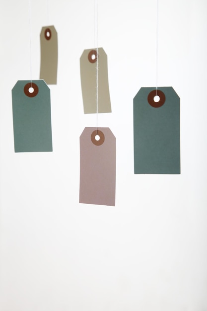 Photo multi colored price tags hanging against white background