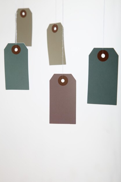 Multi colored price tags hanging against white background