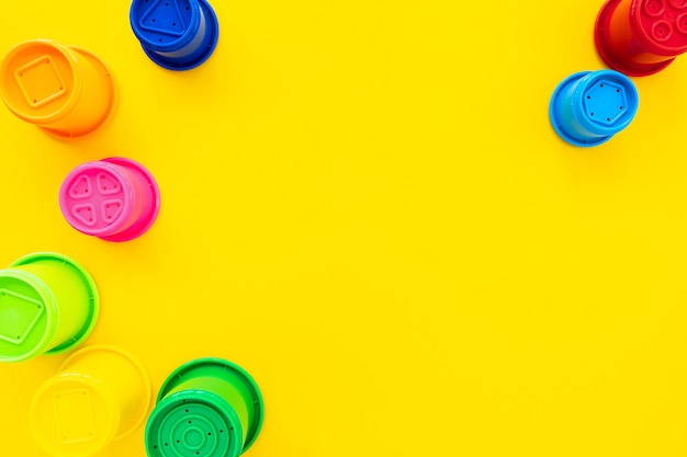 Фото Разноцветные формы радуги для песка на желтом фоне. яркий детский фон, плоская планировка, вид сверху, копия пространства для текста. состав детских игрушек.