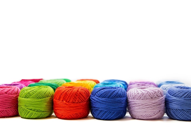 白い背景にマルチカラーの糸のかせ。かぎ針編みや編み物用の天然糸。