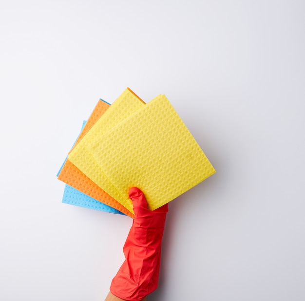 Multi-colored square absorbent sponges in their hands wearing red rubber gloves