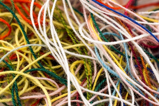 Multi-colored tangled colorful needlecraft silk thread rope. Macro shot. Abstract colors background