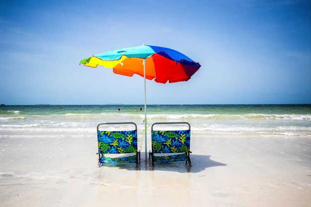 Photo multi colored umbrella on beach against sky