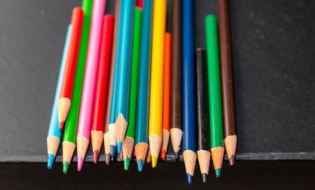 Multi colour pencils isolated on black background Close up shot