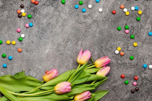 Multi-coloured snoep en tulpenboeket. Bovenaanzicht