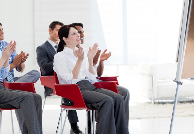 Gente di affari multietnica che applaude alla fine di una conferenza