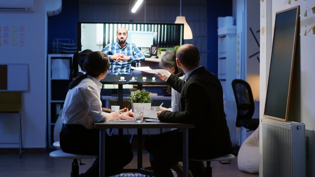 Multi ethnic businesspeople discussing with remote entrepreneur in wheelchair during online videocall