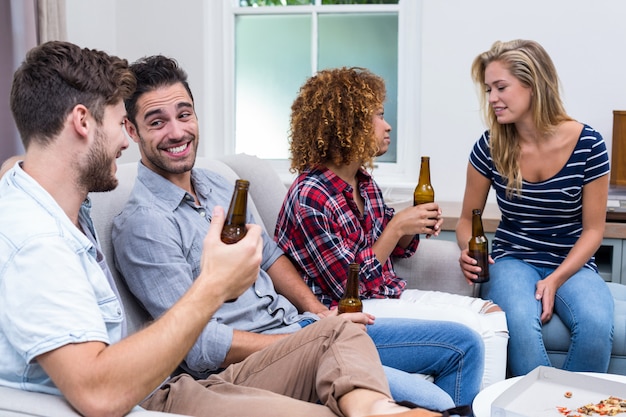 Multi ethnic friends smiling while enjoying beer