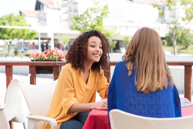 Multi-Ethnic friends talking and having fun at bar's balcony