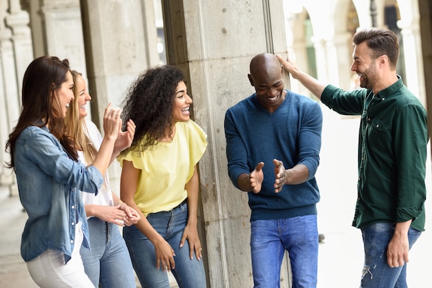 Gruppo multietnico di amici divertendosi insieme all'aperto