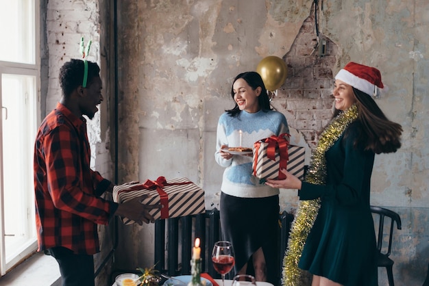 Multi-ethnic people giving a birthday presents to friend at party