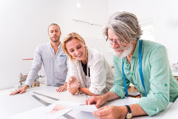 Multi-etnisch team van modeontwerpers werken in een kledingstart-up workshop - Multiraciale groep stylisten, kleermakers en kleermakers werken aan een nieuwe collectie