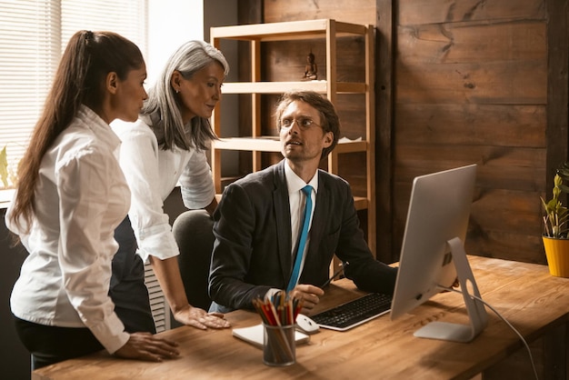 Multi-etnisch zakelijk team van jonge mensen die aan een project werken tijdens zakelijke bijeenkomst diverse werk...