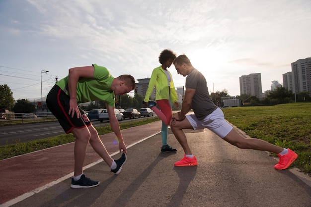 multi-etnische groep jonge mensen op de jogging mooie ochtend als de zon opkomt in de straten van de stad