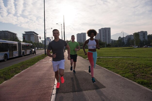 multi-etnische groep jonge mensen op de jogging mooie ochtend als de zon opkomt in de straten van de stad